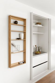 a white wall with shelves and bowls on it