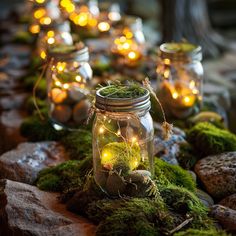 several mason jars filled with moss and lit candles