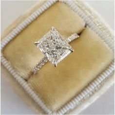 an engagement ring in a velvet box with the diamond set on it's side