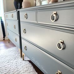 a blue dresser with brass handles and knobs in a living room or dining room