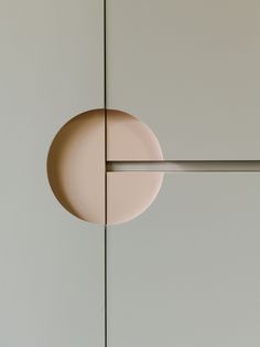 a round object is hanging on the wall next to a metal bar with two bars in it