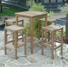 three wooden stools sitting next to each other on a stone patio near a house