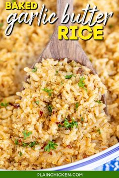 baked garlic butter rice in a blue and white bowl with a wooden spoon full of it