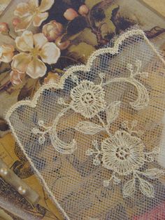 an old lace doily with flowers on it