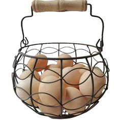 a wire basket filled with eggs sitting on top of a white table next to a wooden handle