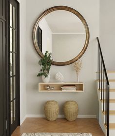 there is a mirror on the wall above two stools and a plant in front of it