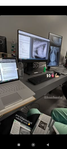 two laptops are sitting on a desk next to a desktop computer and other electronic devices