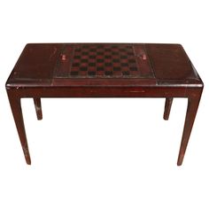 a wooden table with a chess board on it's top and two legs in the middle