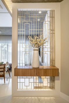 a vase filled with flowers sitting on top of a wooden table next to a window