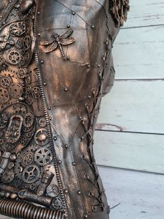 a close up view of the back of a woman's leather jacket with steampunk