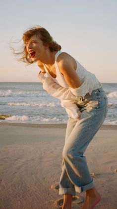 a woman is on the beach with her mouth open and she has one foot in the sand