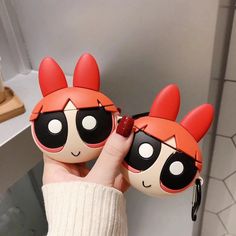 two cartoon dolls are held up in the air with their faces painted red and black