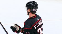 a hockey player holding his stick on the ice