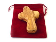 a wooden cross on a red velvet bag