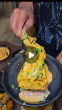 a person cutting up food on top of a black plate