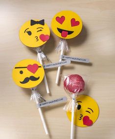 four lollipops with different emoticions on them