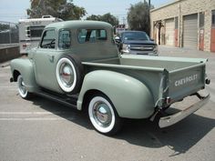 an old pick up truck parked in a parking lot