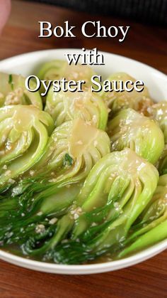 a white bowl filled with cooked artichokes on top of a wooden table