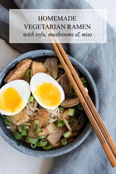 two eggs are placed on top of noodles in a bowl with chopsticks next to it