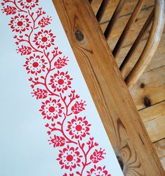 a red and white design on a piece of paper next to a wooden rocking chair