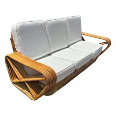 a couch made out of wood and white fabric with two cushions on the back side