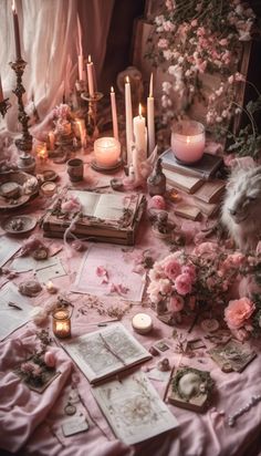 a table topped with lots of books and candles