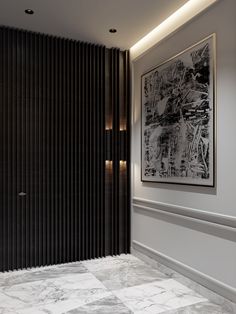 a black and white painting hanging on the wall next to a marble floor in a room