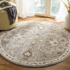 a round rug on the floor in front of a window