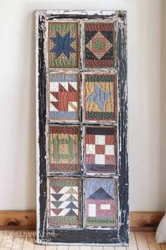 an old window is decorated with colorful quilts