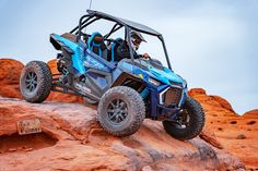 a man riding on the back of a blue polaris rzr