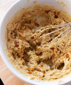 a white bowl filled with batter on top of a wooden table