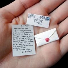 two hands are holding small pieces of paper with words on them and one has a red heart