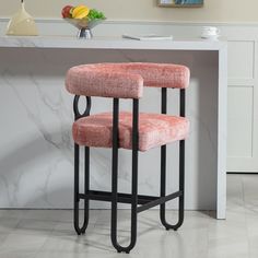 two pink chairs sitting on top of a white counter