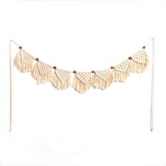 a white wall hanging with tassels and beads