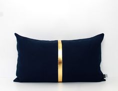 a black and gold pillow sitting on top of a white table