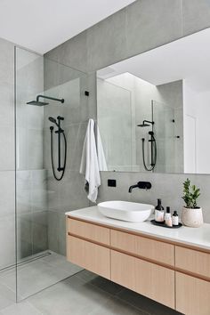 a bathroom with a large mirror and two sinks in front of the bathtub is shown