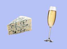 a piece of cheese next to a glass of champagne