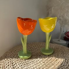 two glass vases sitting on top of a wicker table