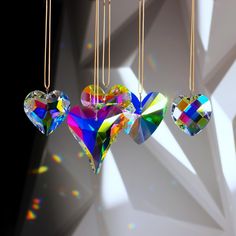 three heart shaped ornaments hanging from gold chains