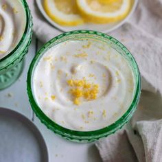 two glasses filled with yogurt and lemon slices