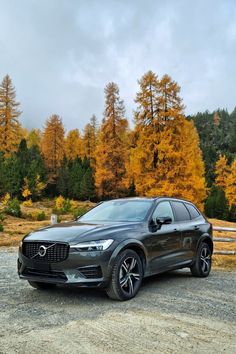 a volvo car parked in front of some trees