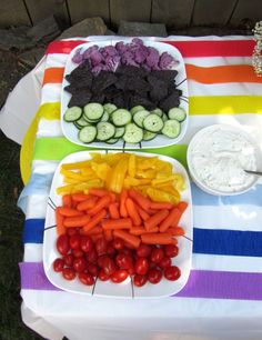 a table topped with plates of vegetables and dip