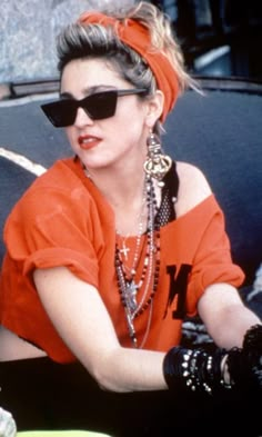 a woman wearing sunglasses and an orange top