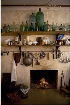 an old fireplace with pots and pans on the mantel in front of it