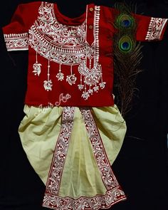 a red and white dress with peacock feathers on the side, next to it is a feather