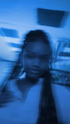 a woman wearing a tie and glasses in a blurry photo with blue light behind her