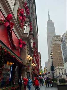 people are walking down the street with christmas decorations