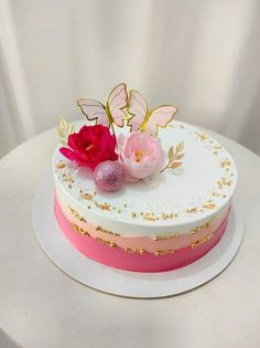 a white cake with pink and gold decorations