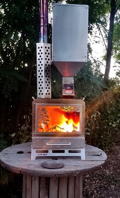 an outdoor stove sitting on top of a wooden table