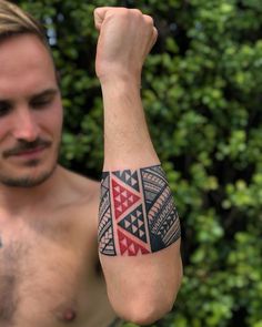 a man with a tattoo on his arm is posing for the camera and holding up his fist